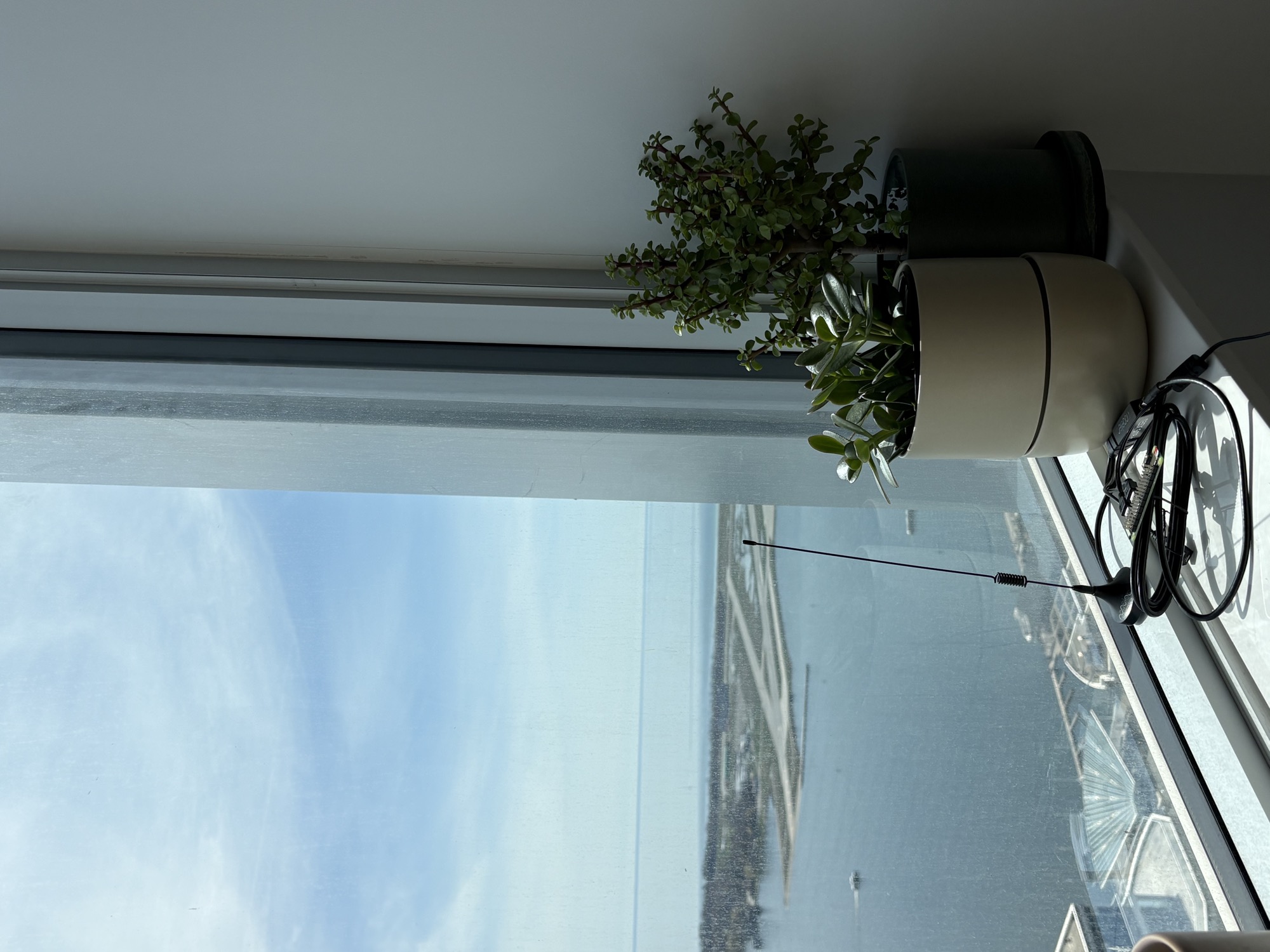 ADS-B antenna on a windowsill with Billy Bishop Airport visible across the harbor